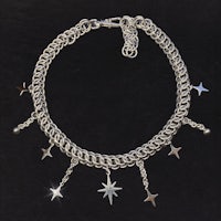 a silver chain choker with stars and charms