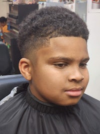 a young boy is getting his hair cut in a barber shop