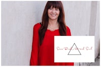 a woman in a red shirt is leaning against a wall with a triangle logo