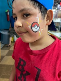 a young boy with a pokemon face painted on his face