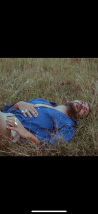 a man in a blue shirt laying in the grass