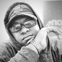 a black and white photo of a man wearing glasses and a hoodie