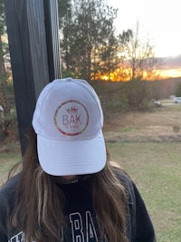 a girl wearing a hat with the word bak on it