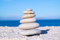 a stack of stones on the beach with the ocean in the background