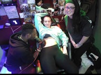 a group of people getting tattoos in a tattoo parlour