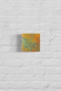 an orange and green abstract painting on a brick wall