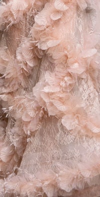 a close up of a dress with pink feathers