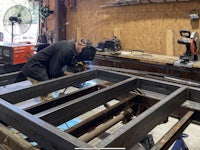 a man is welding a metal frame in a workshop