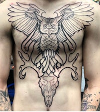 a man with an owl tattoo on his chest