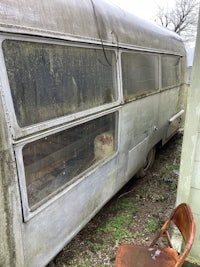 an old silver airstream sitting in a grassy area