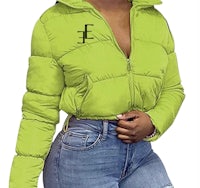a woman wearing a green puffer jacket and jeans
