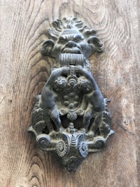 an ornate door knocker on a wooden door