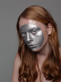 a woman with silver paint on her face