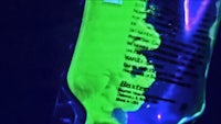 an image of a bottle of green liquid in a dark room