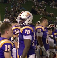 a group of football players standing on the sidelines