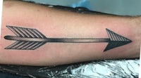 an arrow tattoo on a man's forearm