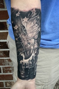 a black and grey tattoo of an eagle on a man's forearm