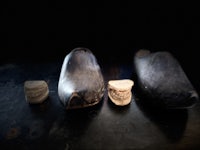 three wooden clogs on a dark table