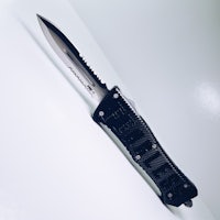 a black knife on a white surface