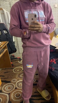 a man wearing a pink hoodie and sweatpants