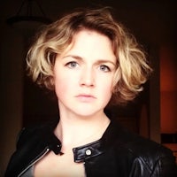 a woman in a leather jacket with short hair