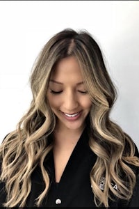 a woman with long wavy hair smiling