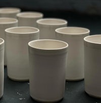 a row of white cups lined up on a table