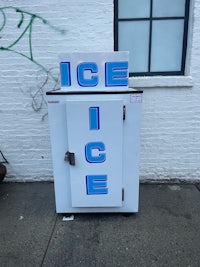 a white ice box with graffiti on it