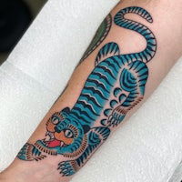 a tattoo of a blue tiger on the forearm