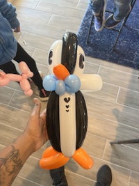 a person holding a penguin balloon