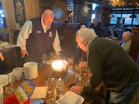 a man blowing out a candle on a birthday cake