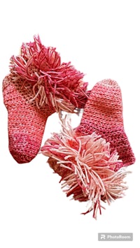 a pair of pink crocheted mittens with tassels