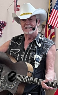 a man in a cowboy hat holding an acoustic guitar