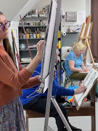 a group of people in an art studio with easels