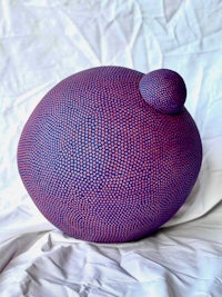 a blue and purple ball on top of a white sheet