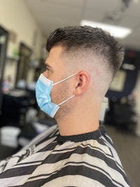 a man wearing a blue face mask in a barber shop
