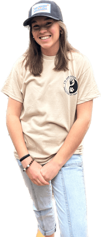 a girl wearing a tan t - shirt and a hat