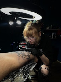a woman getting a tattoo in a tattoo shop