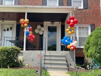 a house with a bunch of balloons on the front porch