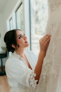 a bride is putting on her wedding dress