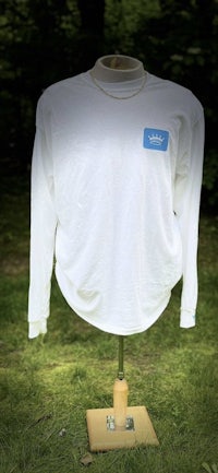 a white long sleeve shirt on a stand in the grass