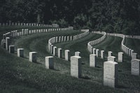 a row of headstones in a grassy field