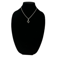 a diamond necklace on a mannequin on a black background