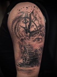 a tattoo of a clock on a man's arm
