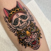 a tattoo of a cat with a skull on it