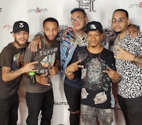 a group of men posing for a picture on a red carpet