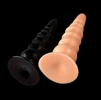 a pair of plastic sex plugs on a black background