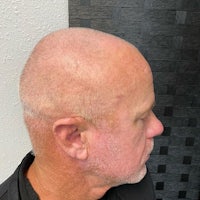 a man with a bald head in front of a mirror