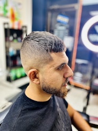 a man sitting in a barber shop with a beard