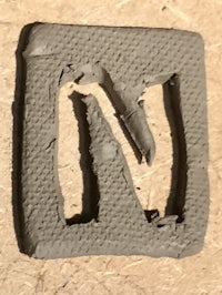 an image of a letter n on a piece of wood